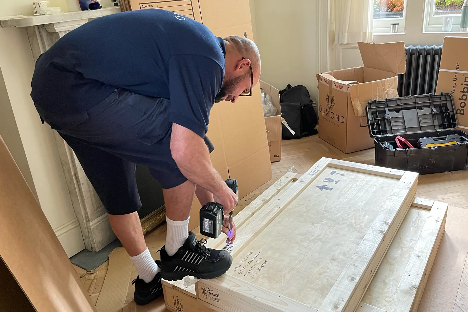 Dumond employee securing a wooden storage crate as part of a carefully packed home move.