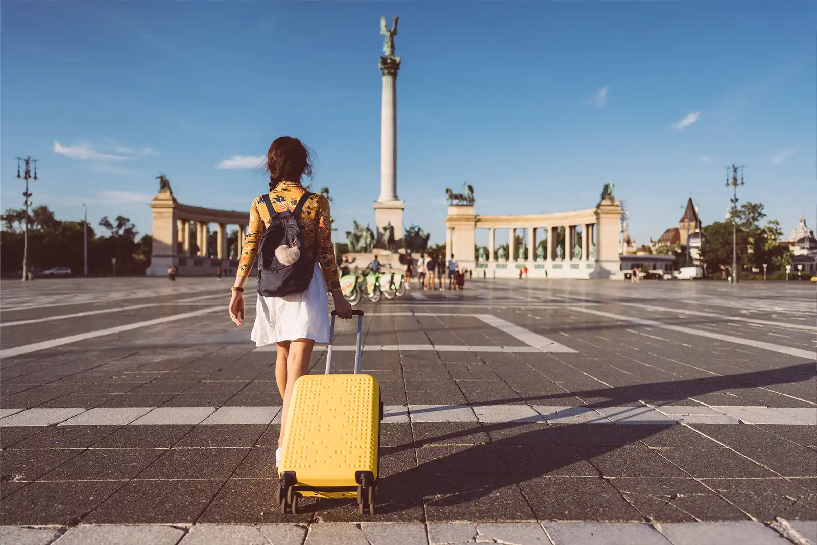Woman walking along a European street with a suitcase representing UK export relocation services.