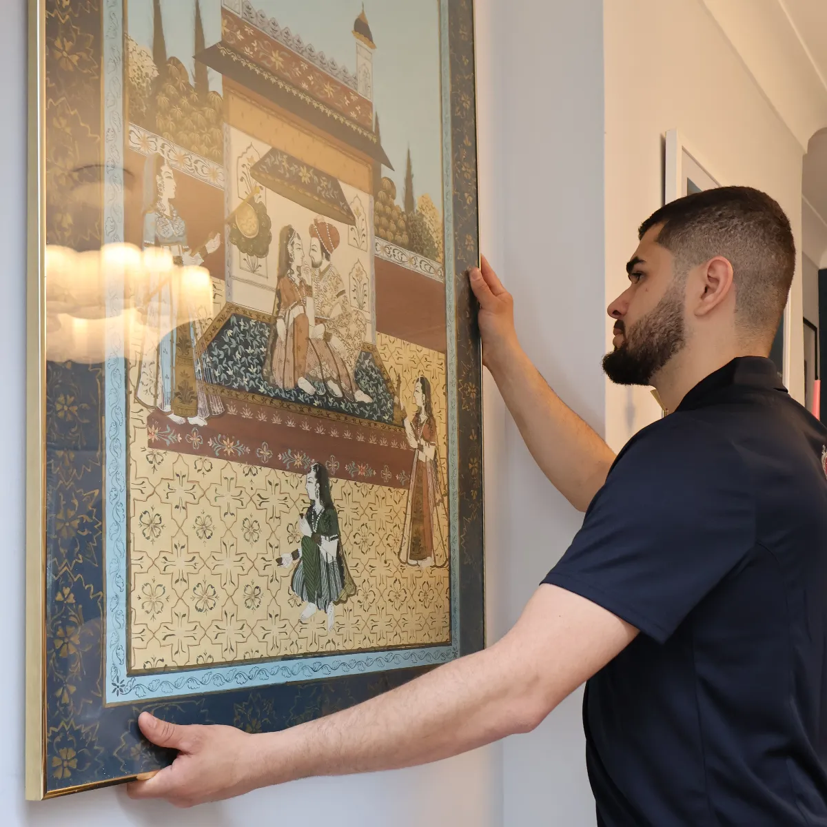 Dumond employee carefully handling framed artwork.