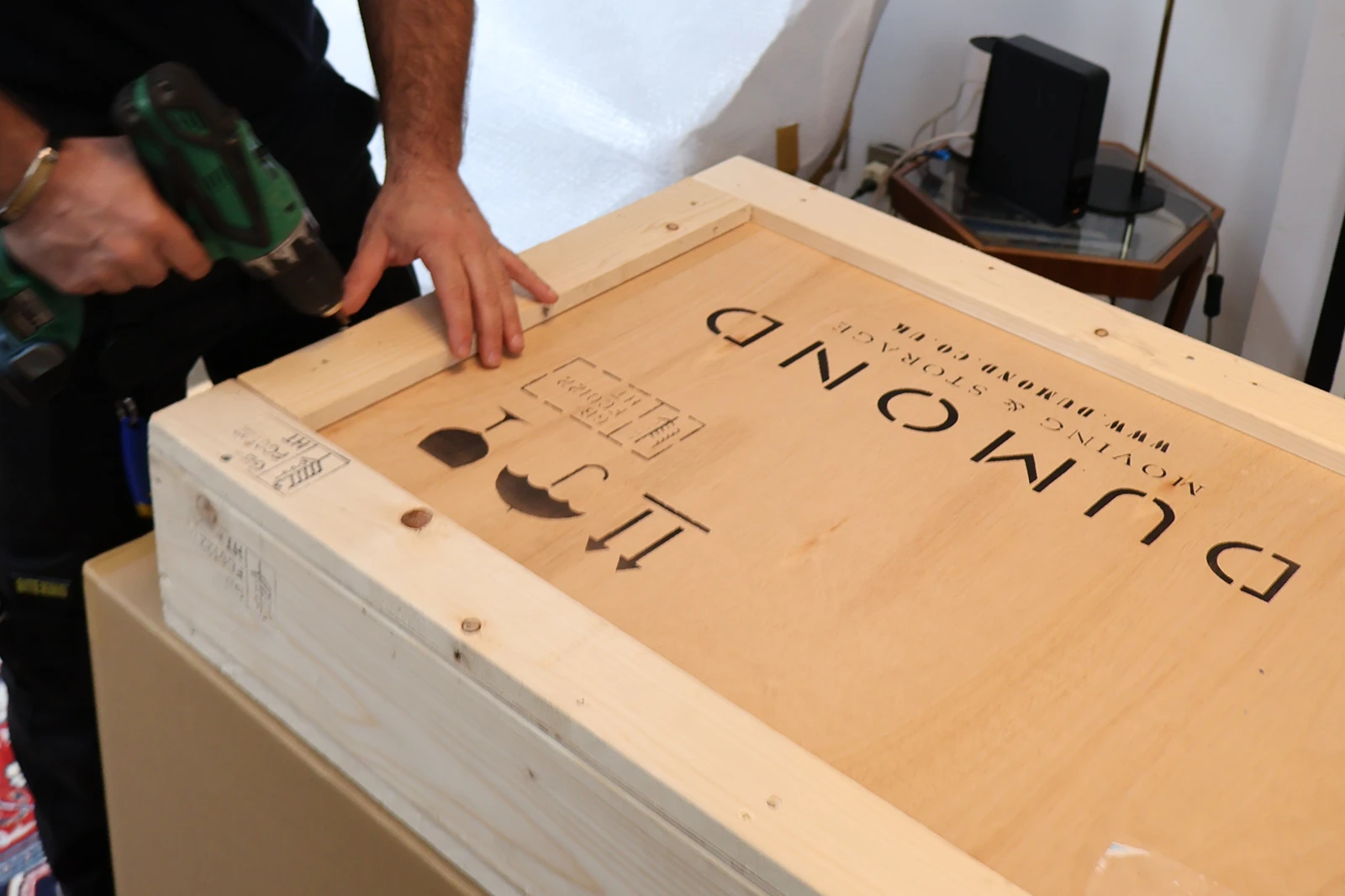 Close-up of a Dumond employee securing a wooden crate for an overseas move.