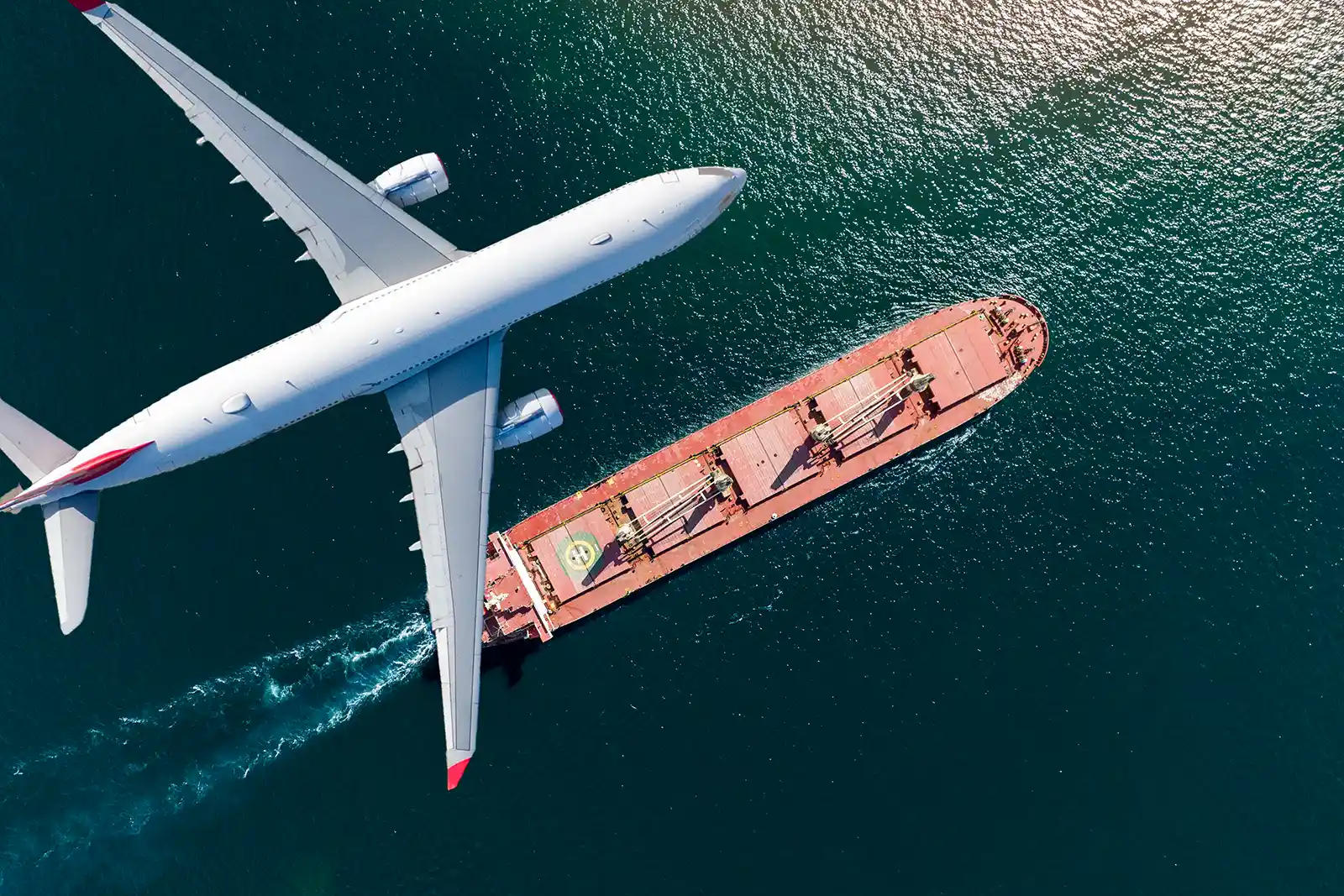 Symbolic image of an aircraft flying above a cargo ship representing international removals.