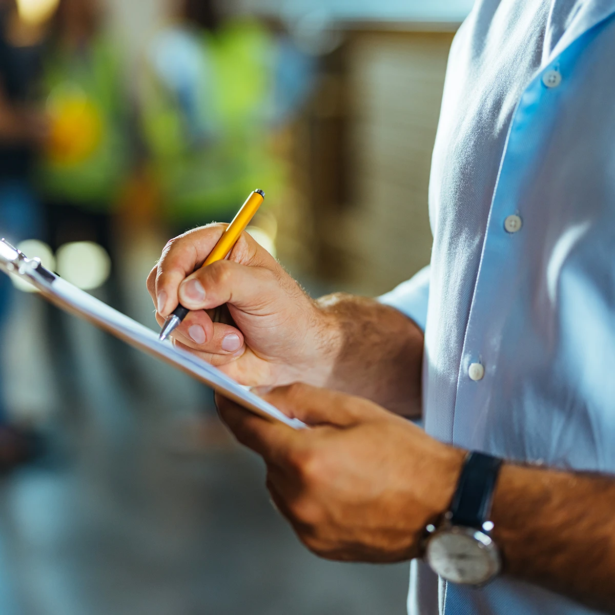 Close-up of a Dumond employee writing survey notes in a warehouse for an international relocation.